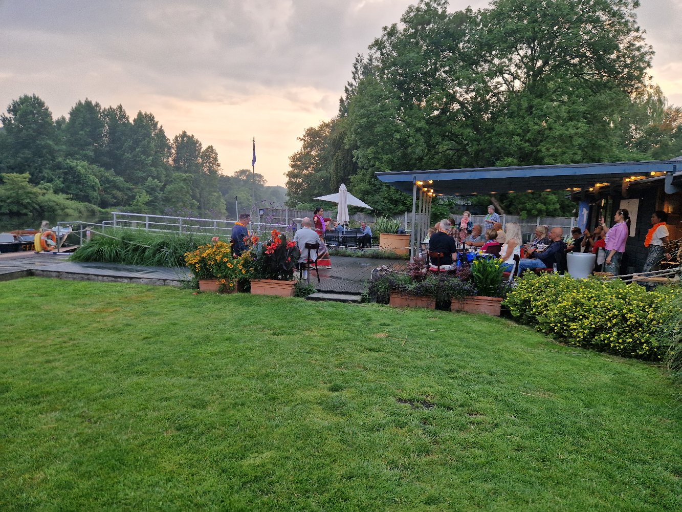 Summer evening at Thorpe Ferry Café, guests dining on the deck at sunset